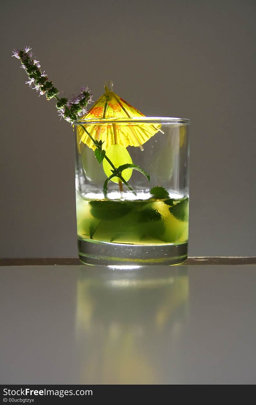 Mohito glass in studio with mint flower and umbrella decoration. Mohito glass in studio with mint flower and umbrella decoration