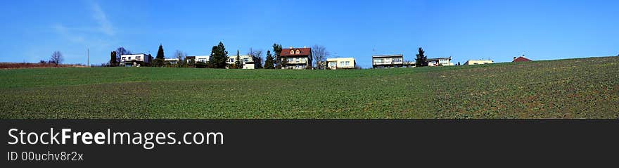 A panorama with square, blue sky and some houses in small village