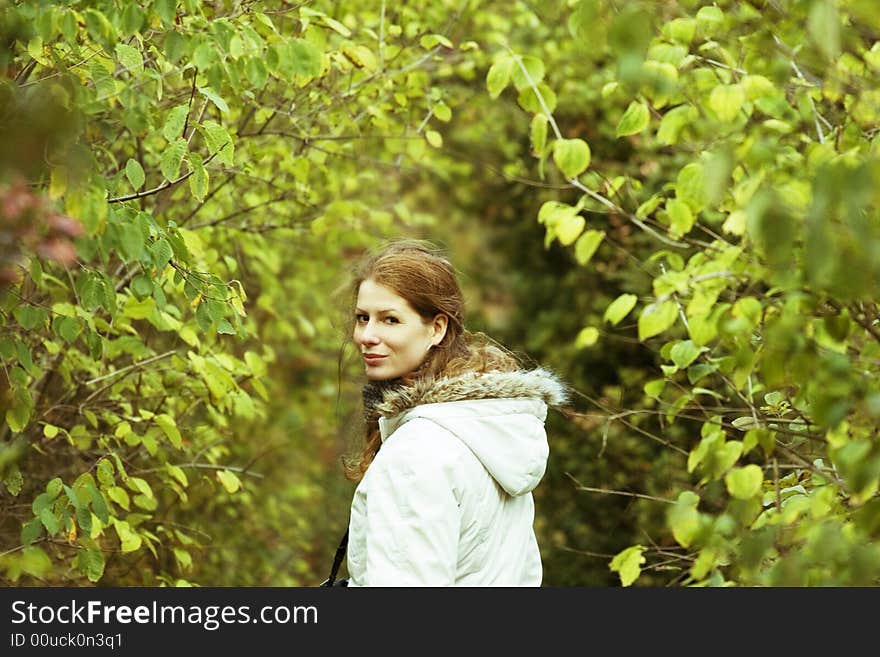 Girl walking in the park, way with green leaves