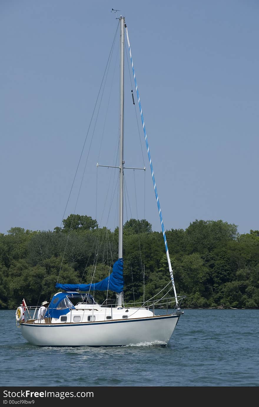 A white-hulled Canadian boat motoring on the Niagara river at the height of summer. A white-hulled Canadian boat motoring on the Niagara river at the height of summer.