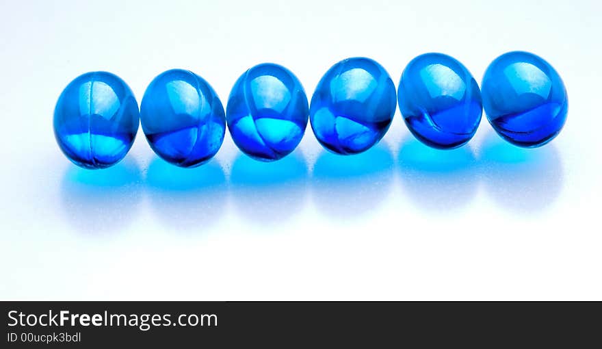 Blue pills in a row isolated on white background. Blue pills in a row isolated on white background