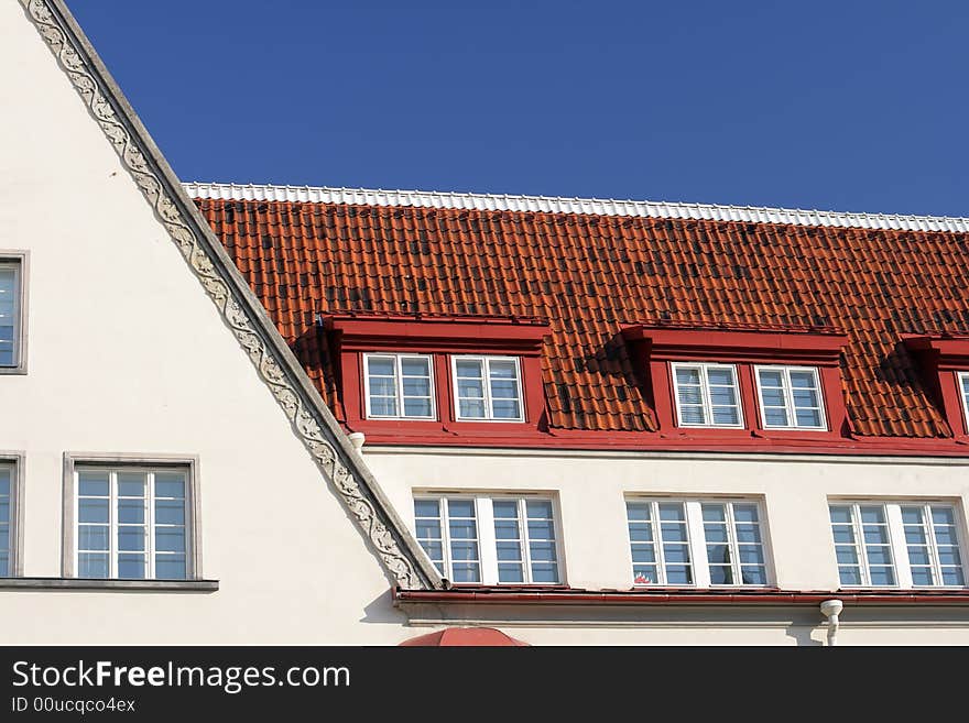 White house with tiled roof and blue sky