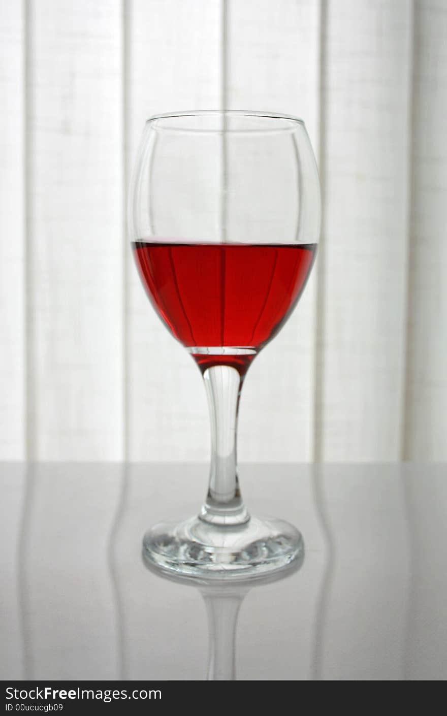 Single wine glass with red wine on a white background. Single wine glass with red wine on a white background