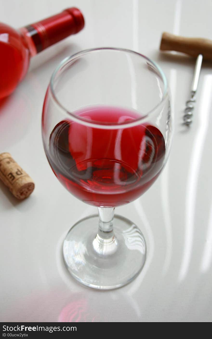 Red wine glass with corkscrew and cork