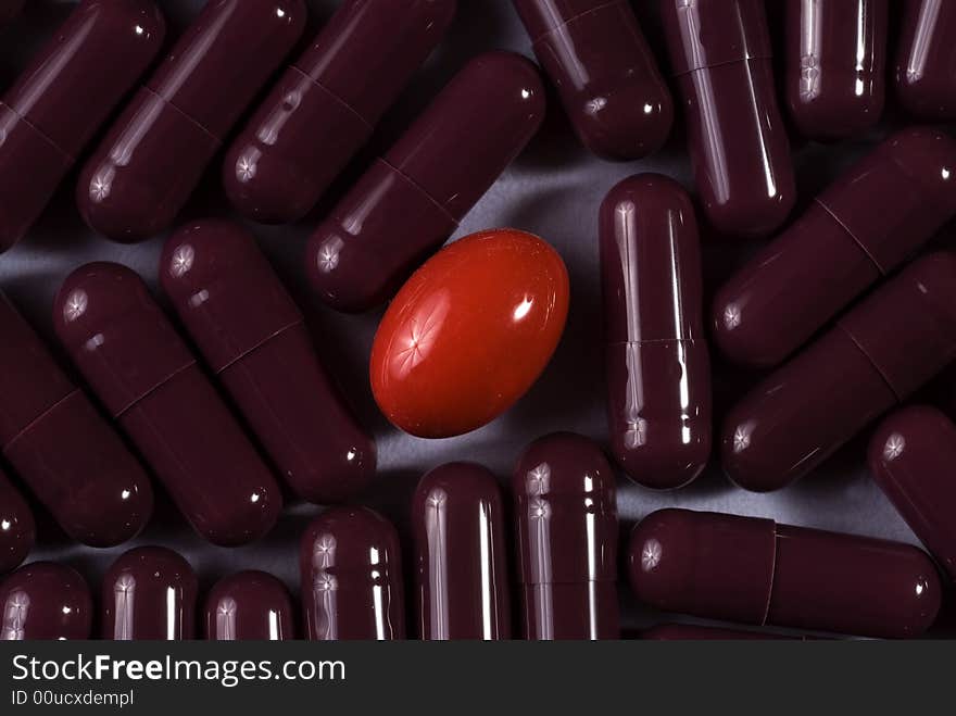 A lot of same capsules with red pill in the middle. A lot of same capsules with red pill in the middle