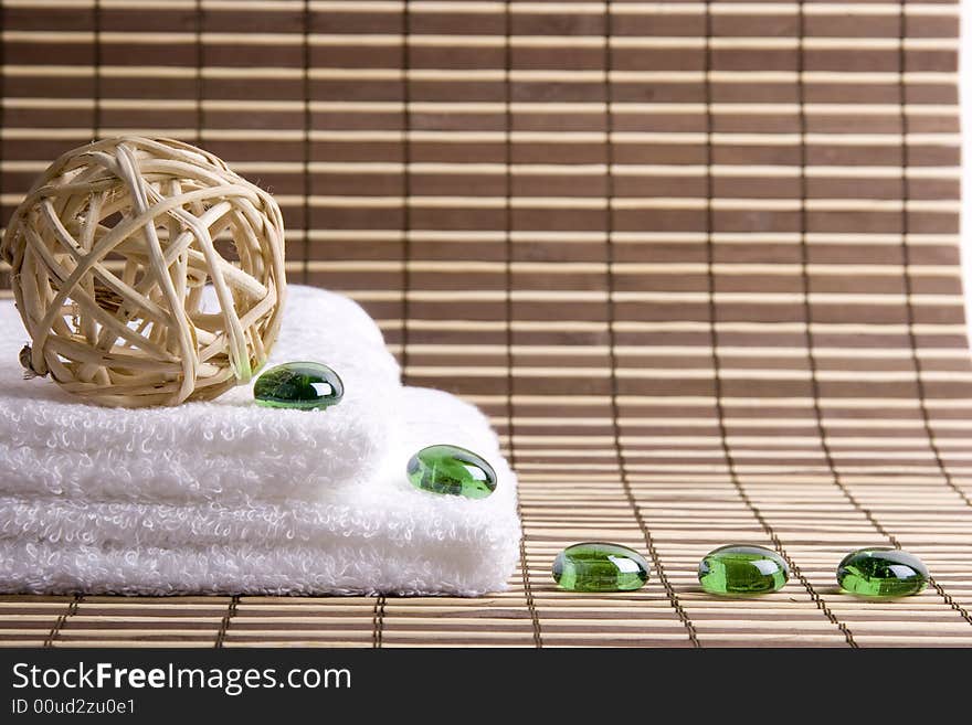 Two white towels and five glass green stones. Two white towels and five glass green stones