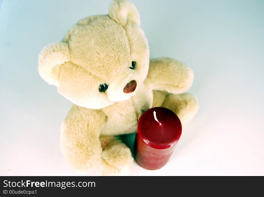 Teddy-bear and unlit candle