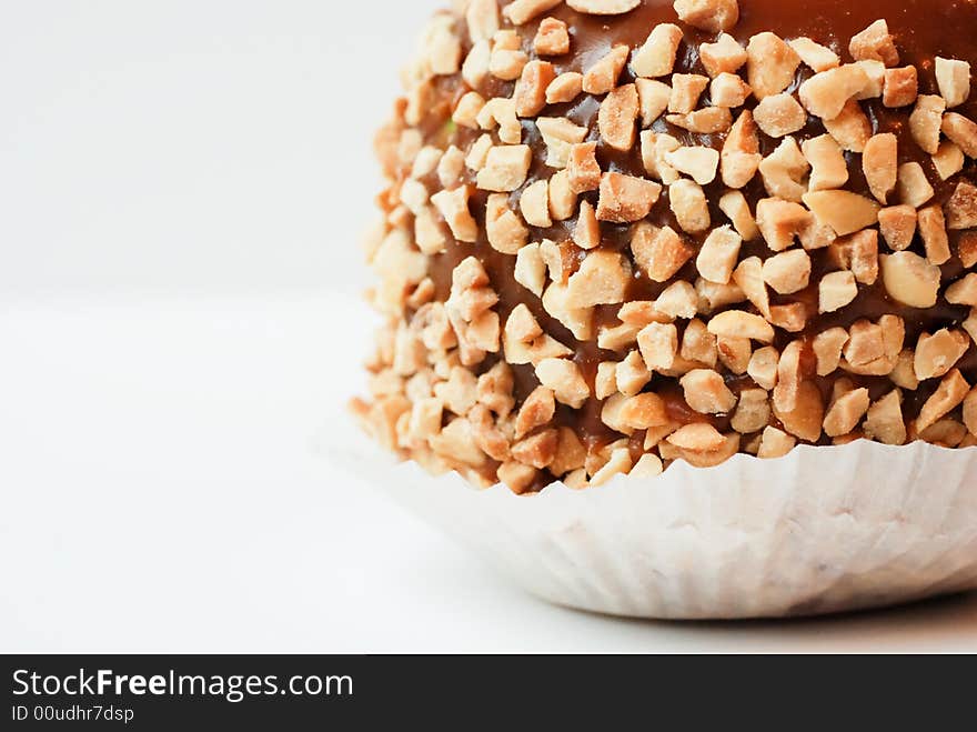 A green caramel apple with nuts with a white background. A green caramel apple with nuts with a white background.