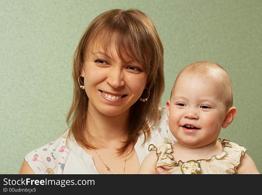 Smiling mother with the child on a green background. Smiling mother with the child on a green background