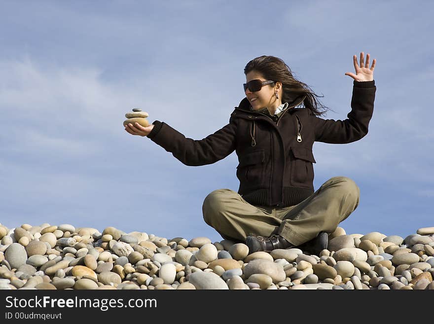 Young casual woman holding pile of round stones