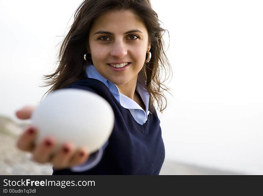 Young casual happy woman holding small white rock. Young casual happy woman holding small white rock