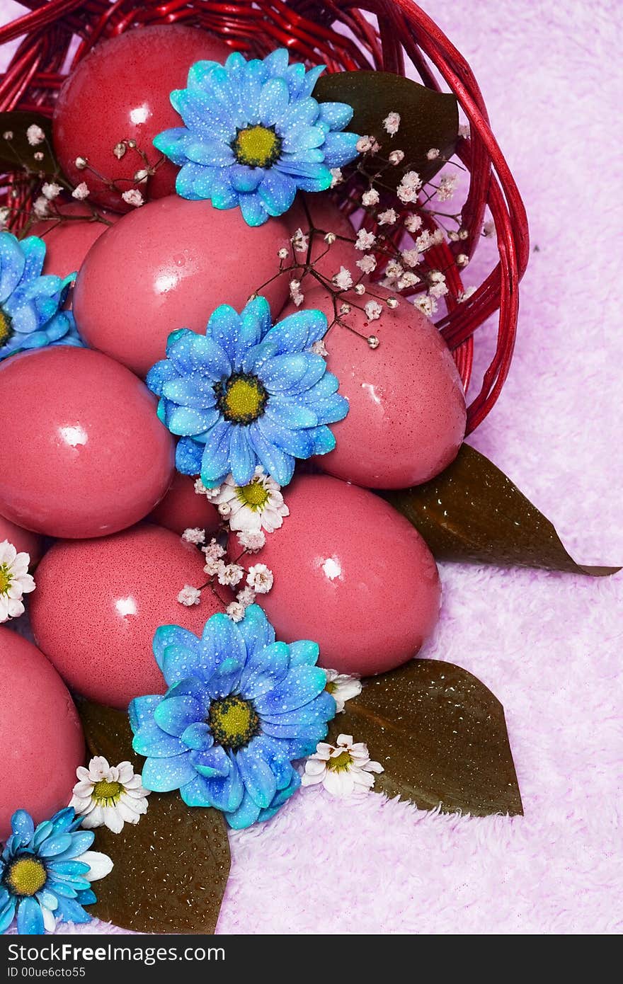 Red easter eggs with blue flowers on basket