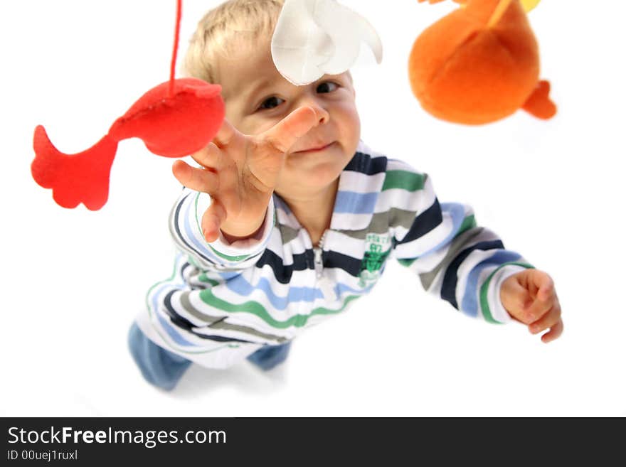 Young boy reaching for his hanging toys. Young boy reaching for his hanging toys