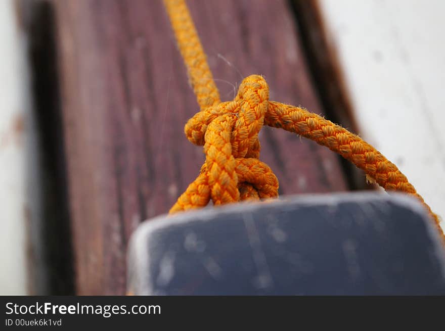 An orange colored rope tied in a knot