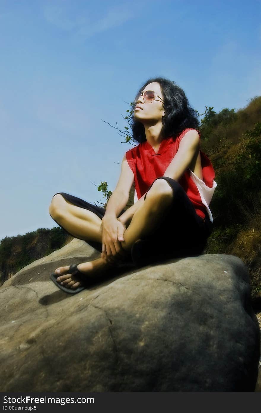 Young man sitting on rock by the beach. Young man sitting on rock by the beach