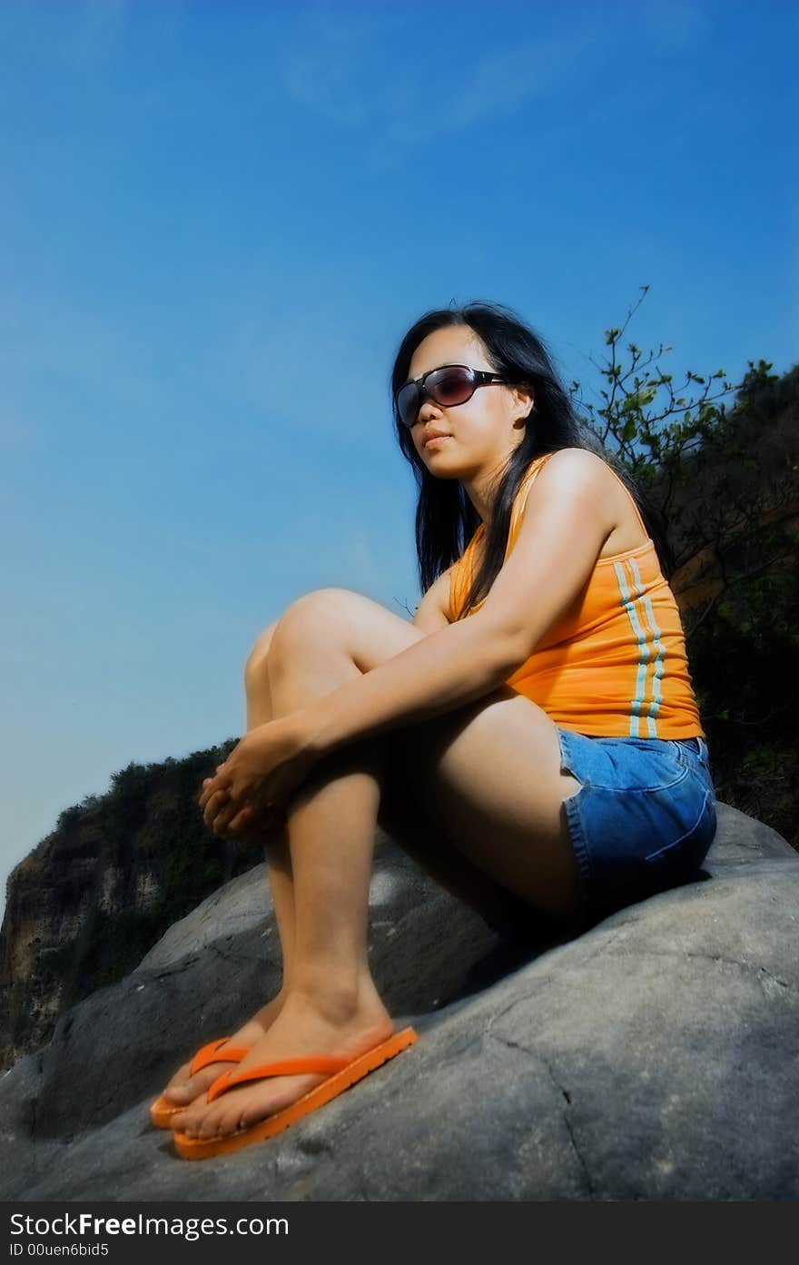 Asian woman on rock by the beach