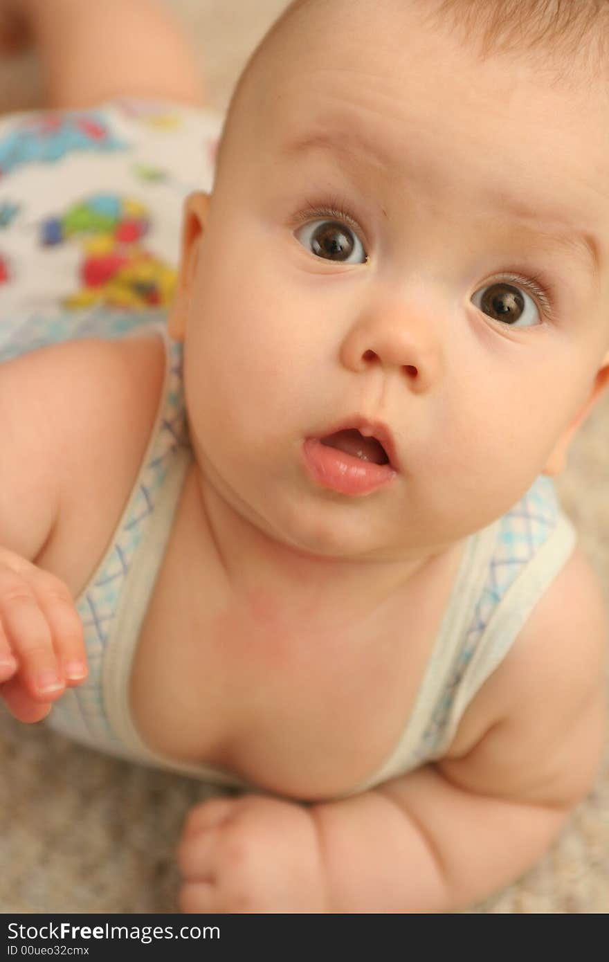 The surprised child lays on a floor