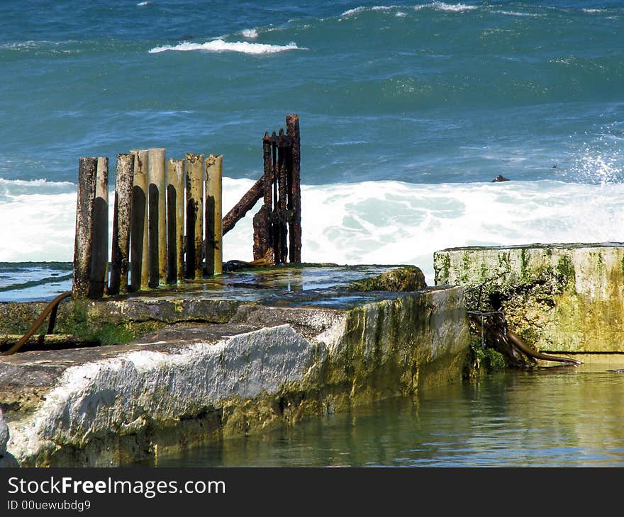 Broken fence on a sea break wall. Broken fence on a sea break wall