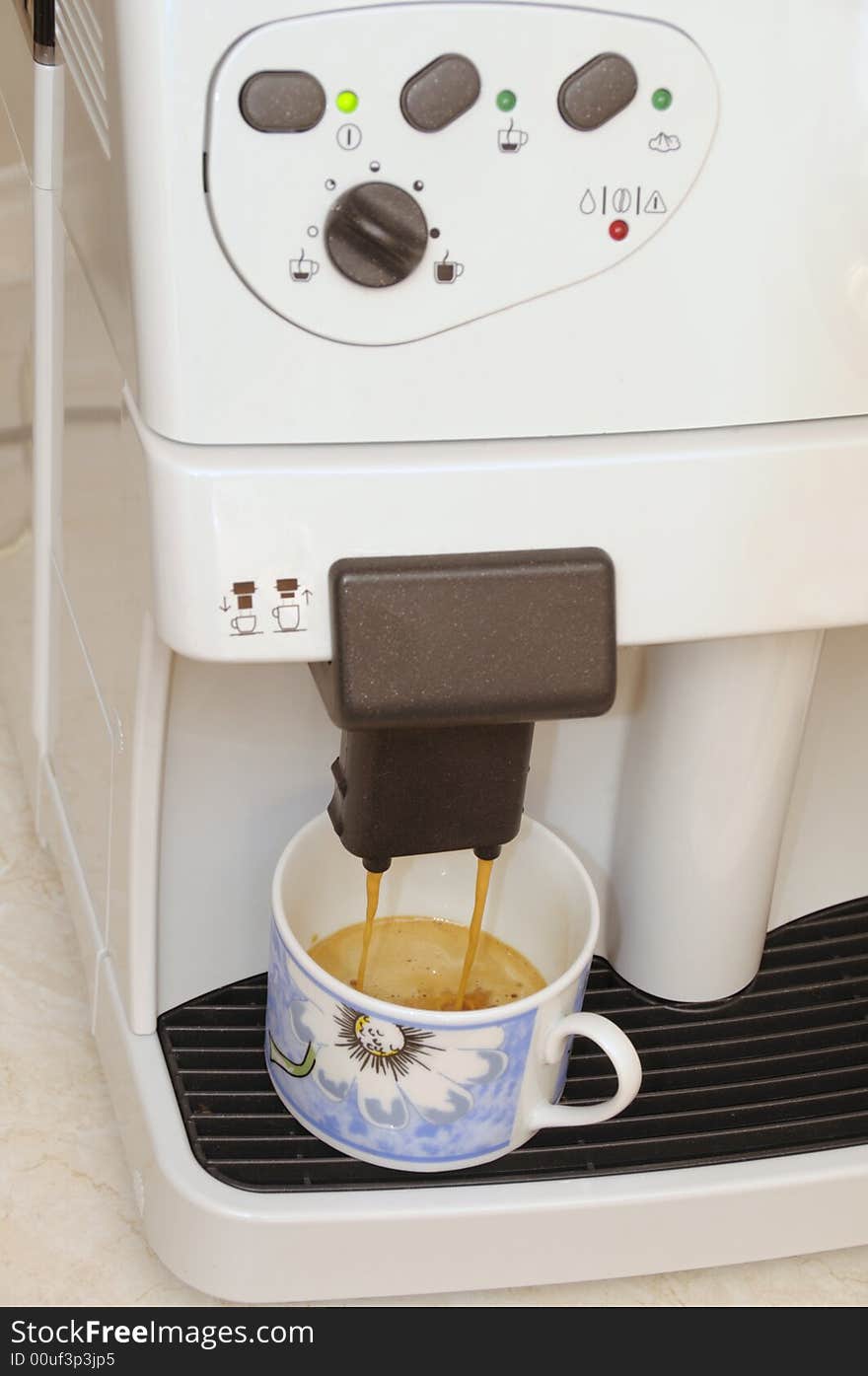 A cup at the ready in an expresso machine. A cup at the ready in an expresso machine.