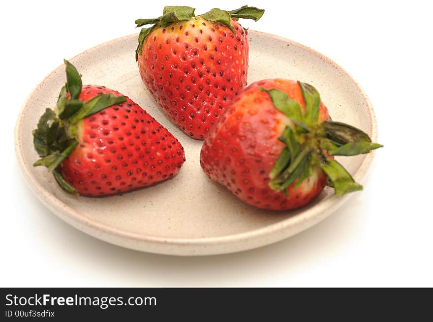 Strawberries berries on the ceramic plate, isolated on a white background