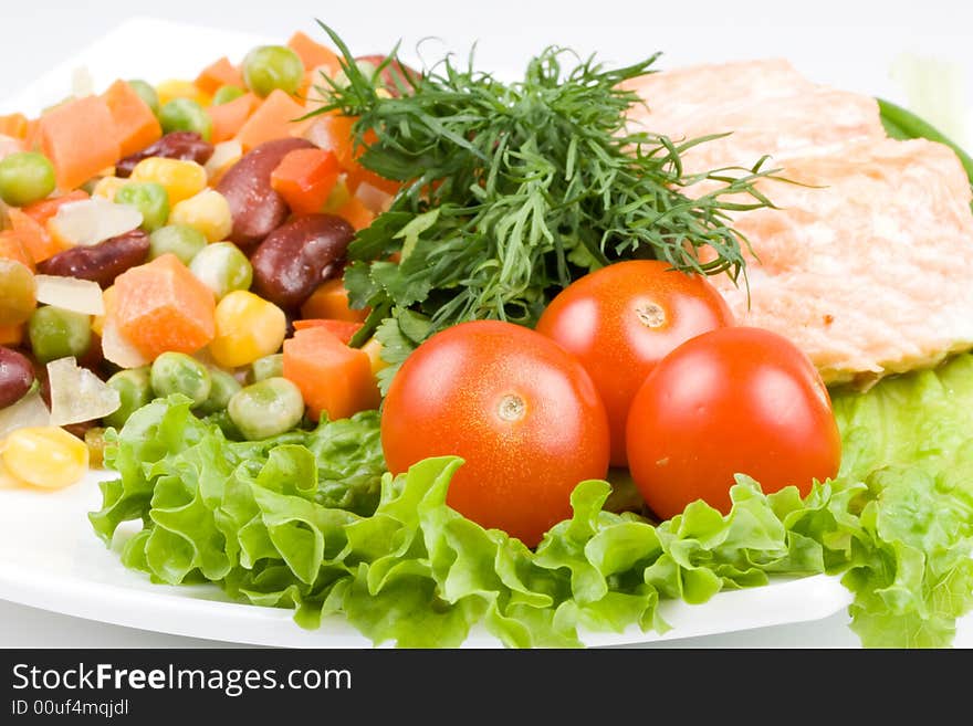 Stake from a salmon with vegetables on a plate close-up.