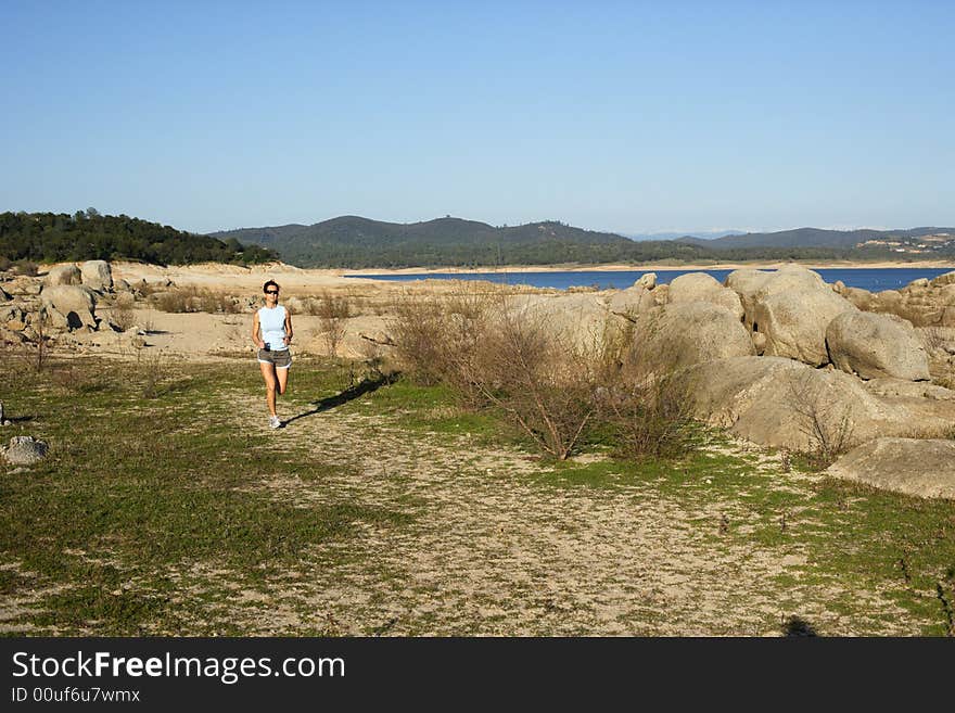 A woman running down a path at the beach