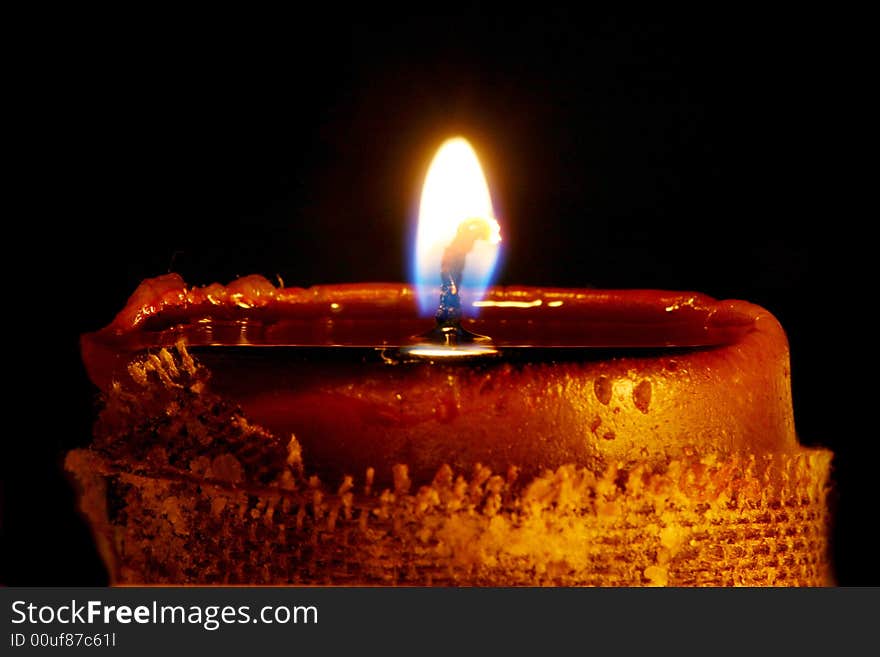 Close up shot of isolated on black glowing candle. Black background. Macro shot, combied from 3 shots to achieve bigger depth of field.