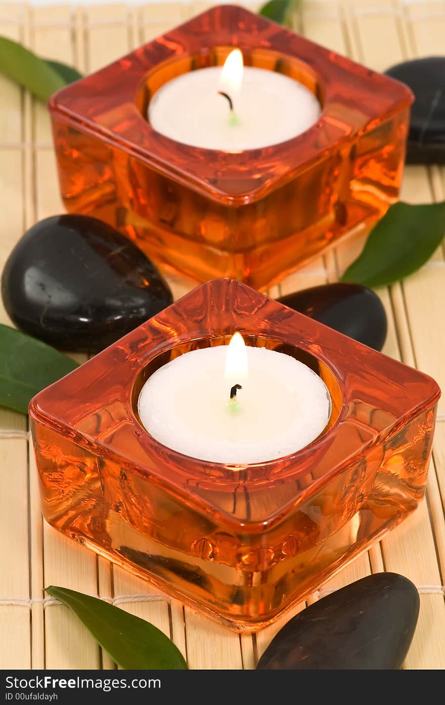 Spa stones, candles and green leaves on bamboo. Spa stones, candles and green leaves on bamboo