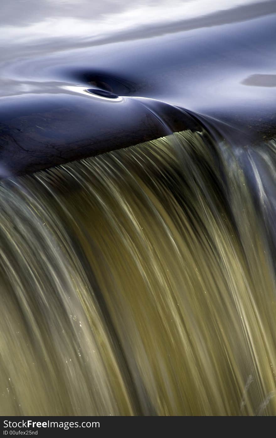 Whirlpool forms at the edge of a small waterfall. Whirlpool forms at the edge of a small waterfall