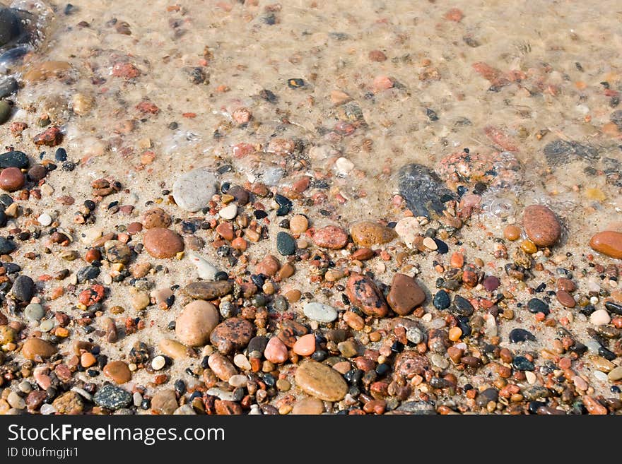 Wet pebbles on a beach background. Wet pebbles on a beach background