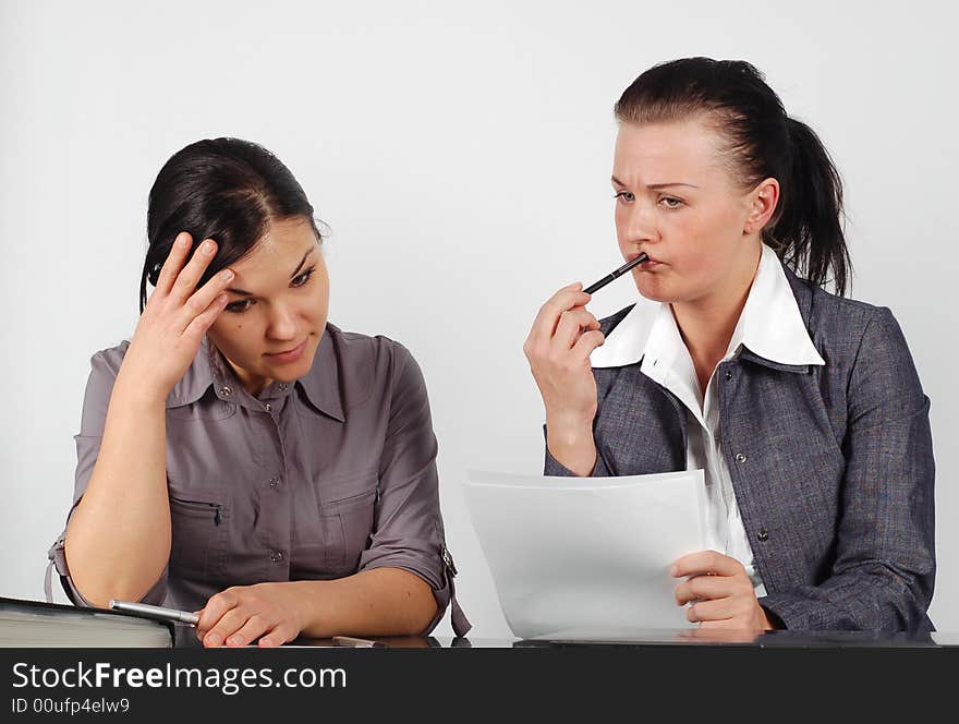 Two attractive brunette businesswomen working in office. Two attractive brunette businesswomen working in office