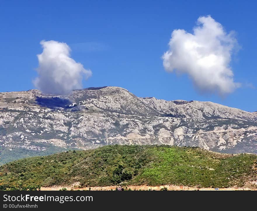 Two distinct clouds over the mountains to sunny da