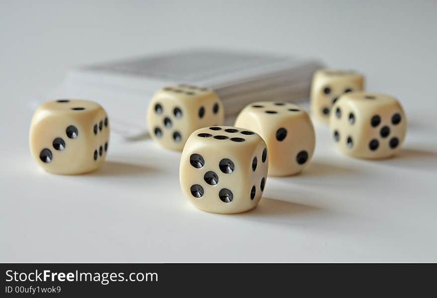 Dice and cards on a white table,focus on a foreground