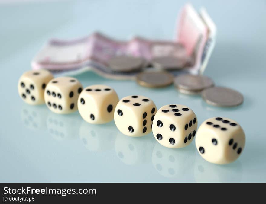 Dice and money on a glass table,focus on a foreground