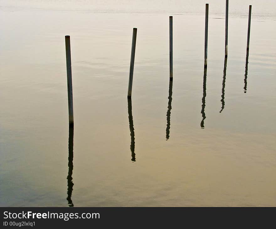 Poles sticking out of lake on a diagonal line. Poles sticking out of lake on a diagonal line