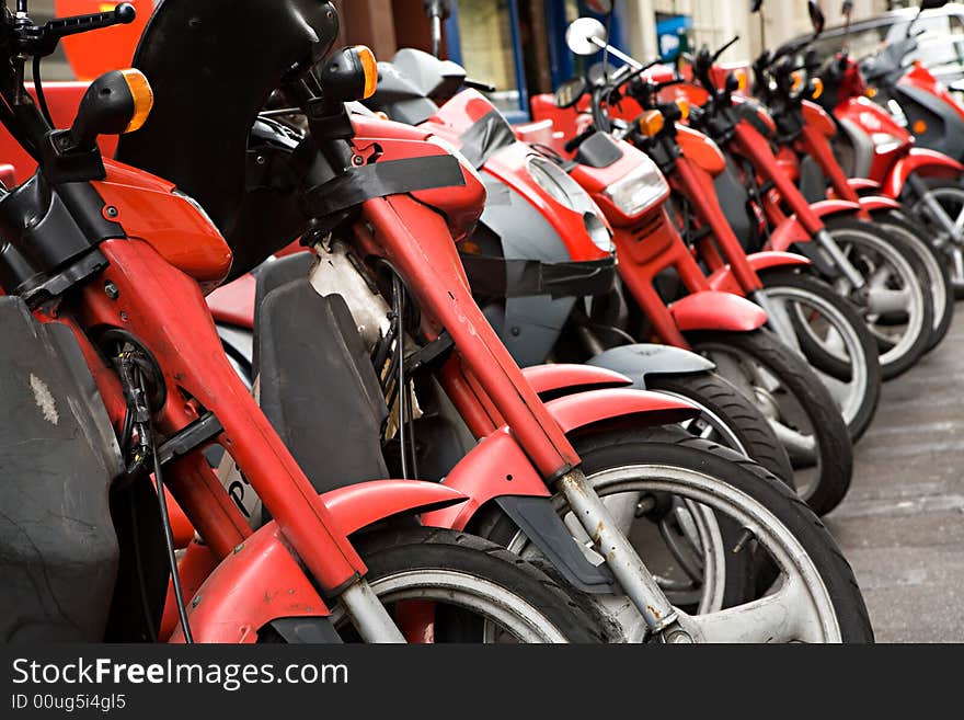 Many red motorcycles stand in a row. Many red motorcycles stand in a row