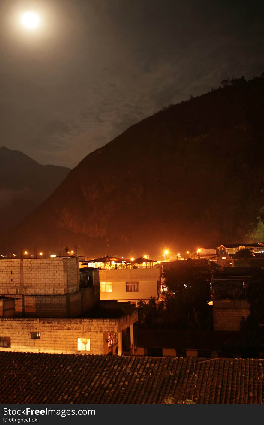 The town of Banos, Ecuador light up under a full moon. The town of Banos, Ecuador light up under a full moon