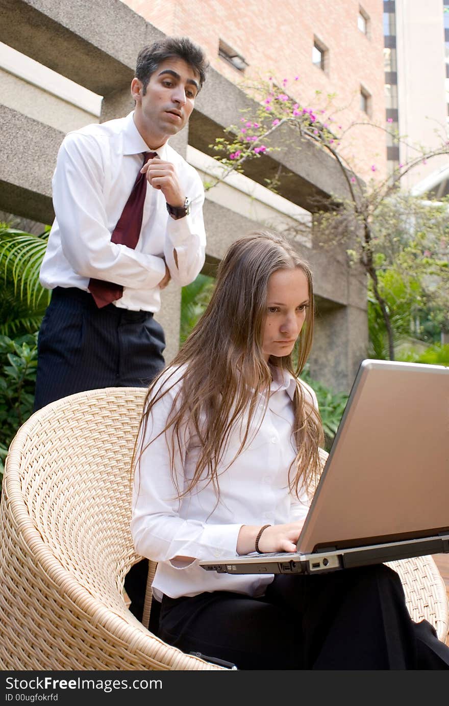 Businessman and woman looking at a laptop together. Businessman and woman looking at a laptop together.