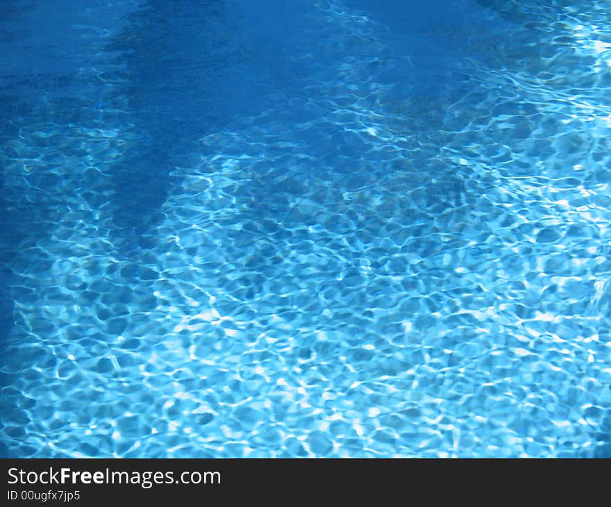 Blue pool water with palm reflection