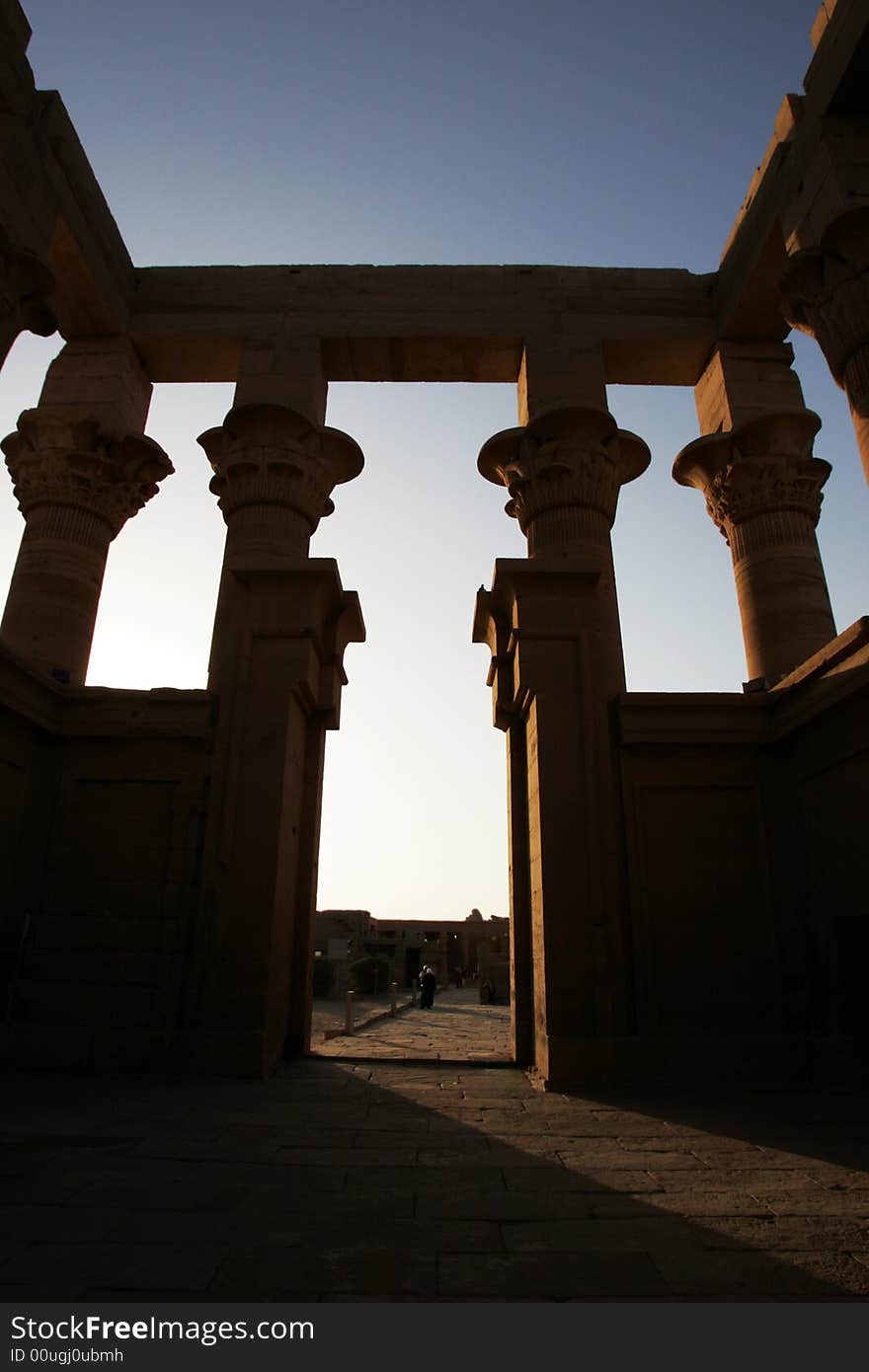 Old ruins of a temple shot from the inside to create a moody silhouette of the large pillars