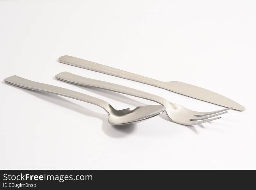 Metal spoon, fork and knife on a white background. Metal spoon, fork and knife on a white background