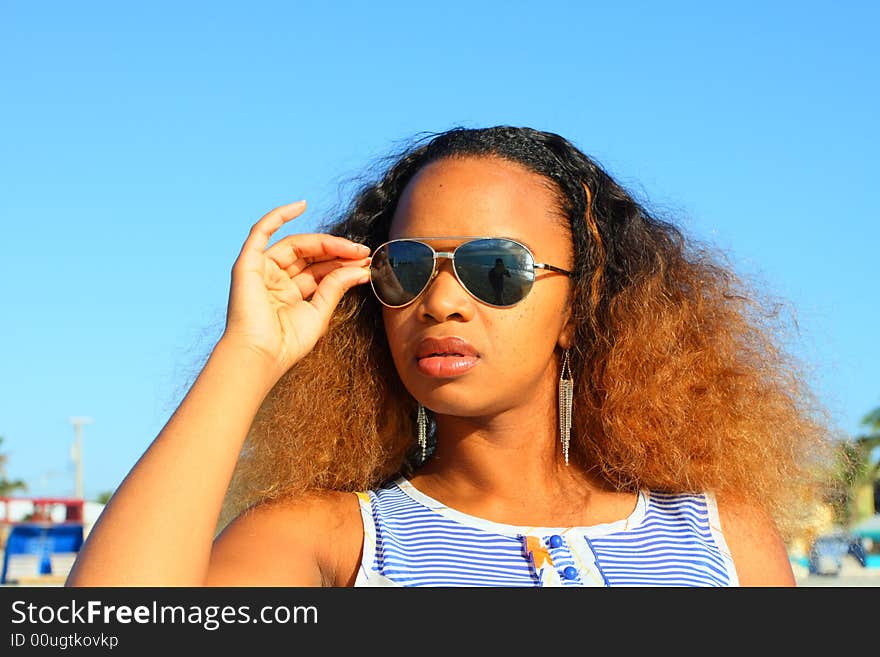 Woman fixing her sunglasses which have a beautiful reflection of the sunrise. Woman fixing her sunglasses which have a beautiful reflection of the sunrise.