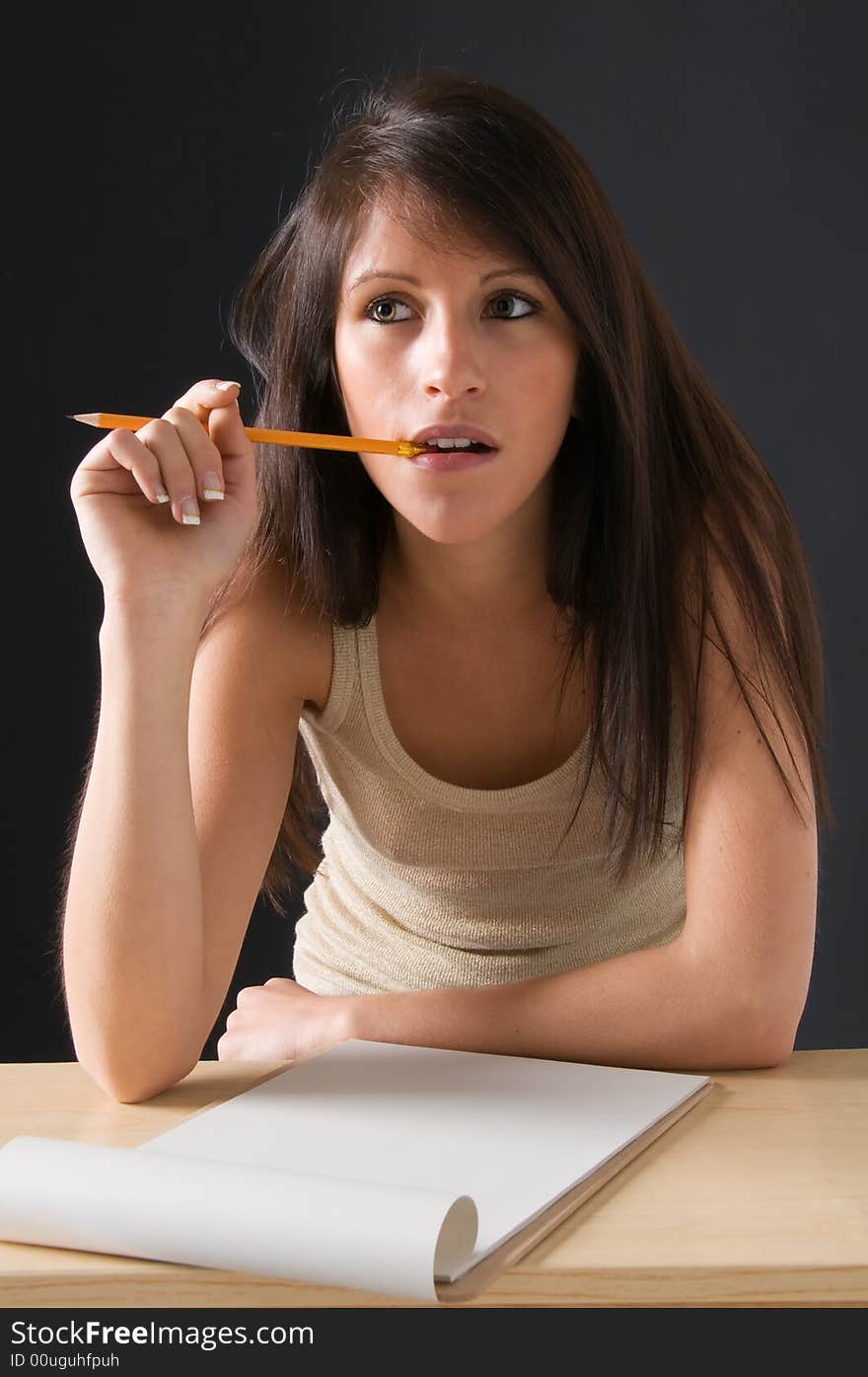 Portrait of a beautiful Isolated teenager student. An attractive young student posing at her desk. Picture of a pretty girl isolated on a dark background. Portrait of a beautiful Isolated teenager student. An attractive young student posing at her desk. Picture of a pretty girl isolated on a dark background.