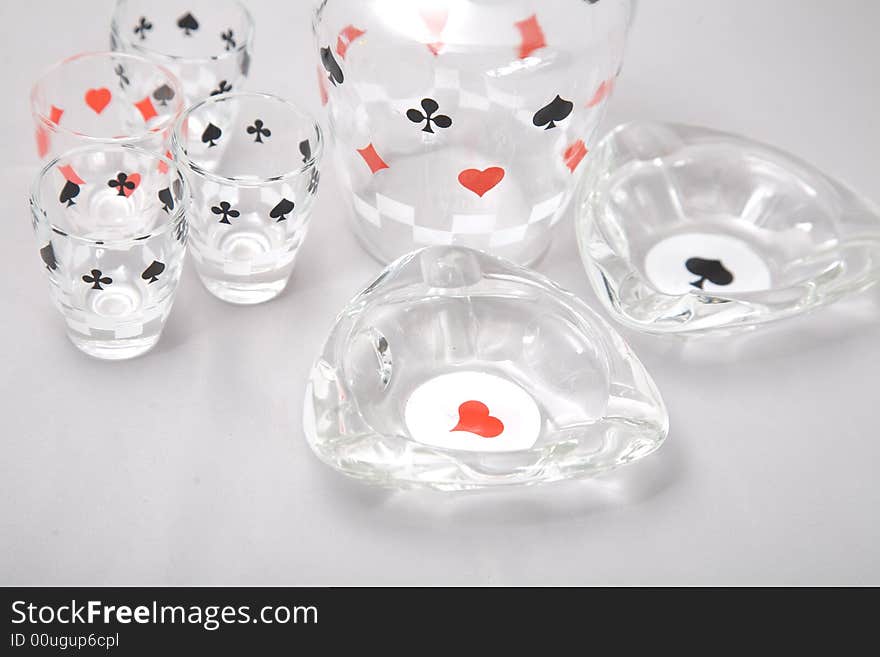 A set of liquor glasses and ashtrays with cards pattern