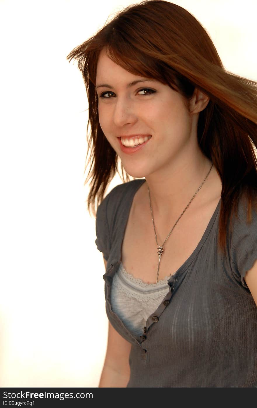 Portrait of a beautiful girl with brown straight hair blowing against white background. Portrait of a beautiful girl with brown straight hair blowing against white background.