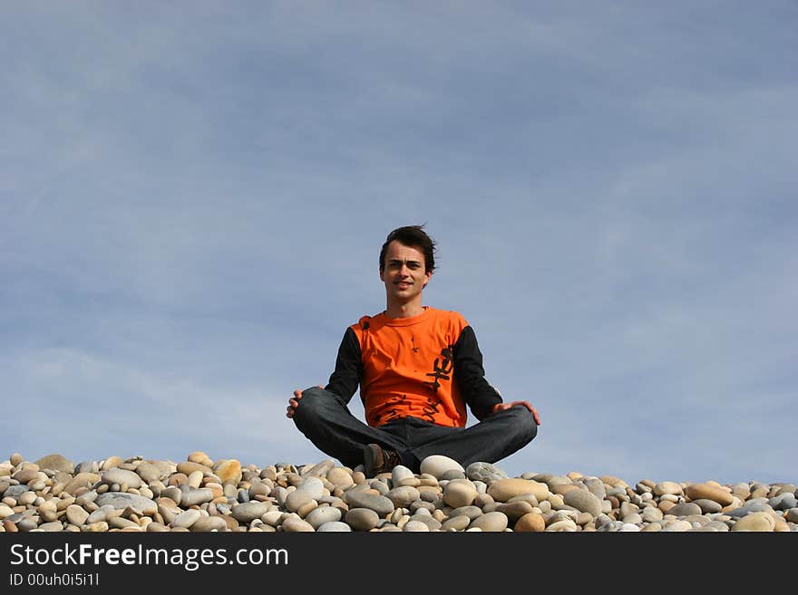 Young casual man at the beach isolated over blue sky background