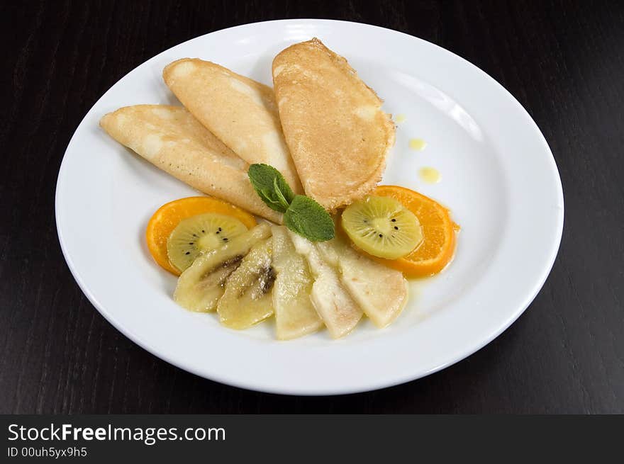 Pancakes with fruit on a white plate. Pancakes with fruit on a white plate.