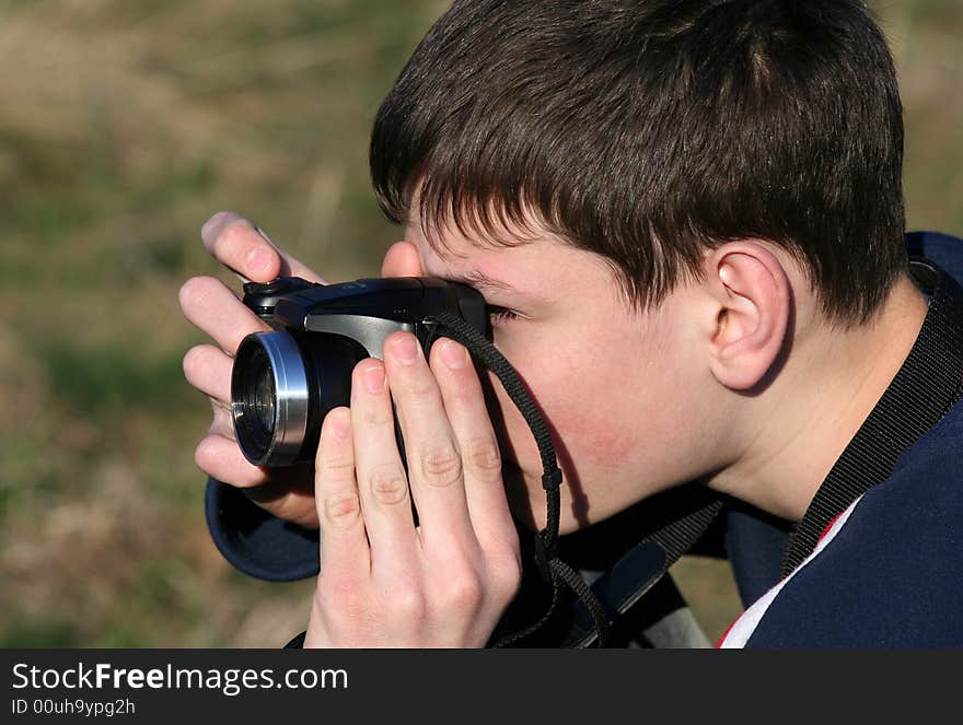 Young boy taking photos with black camera