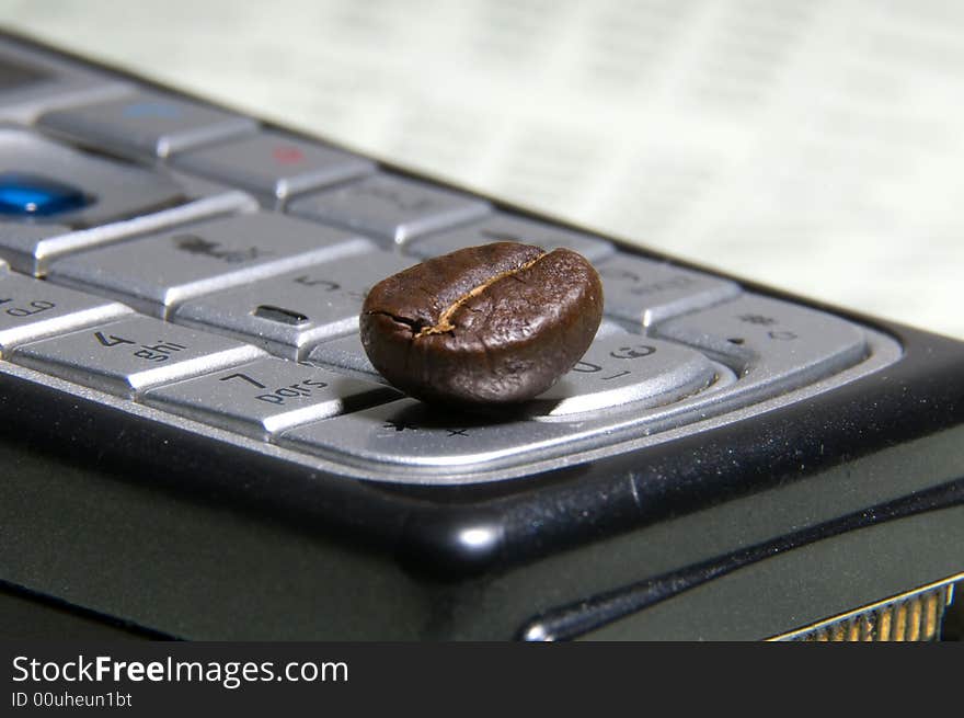 Business coffee. Coffee bean lying on a mobile phone.