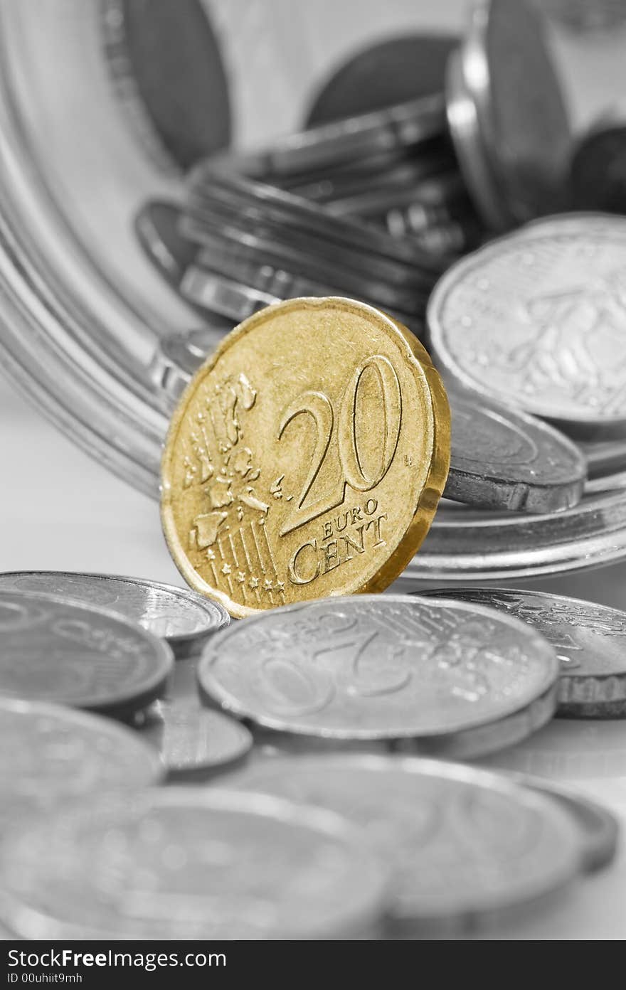 Euro cents rolling out of pot. Focus on twenty cents.